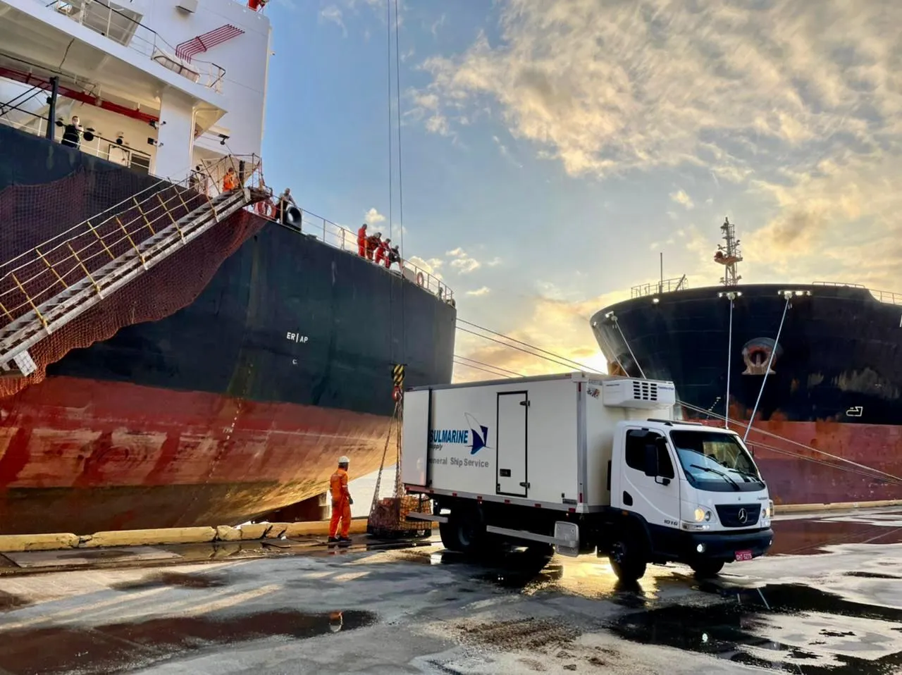 Caminhão refrigerado da Sul Marine abastecendo navio no porto ao pôr do sol